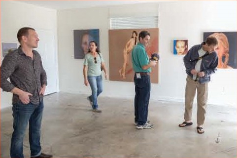 Image of four people looking at paintings in an art gallery